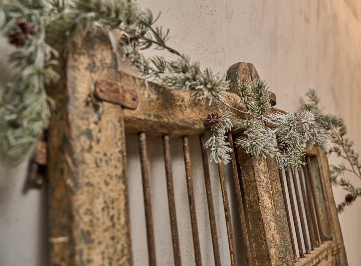 Gammel gårdsport pyntet med kunstig, frostet cedergirlande fra Speedtsberg