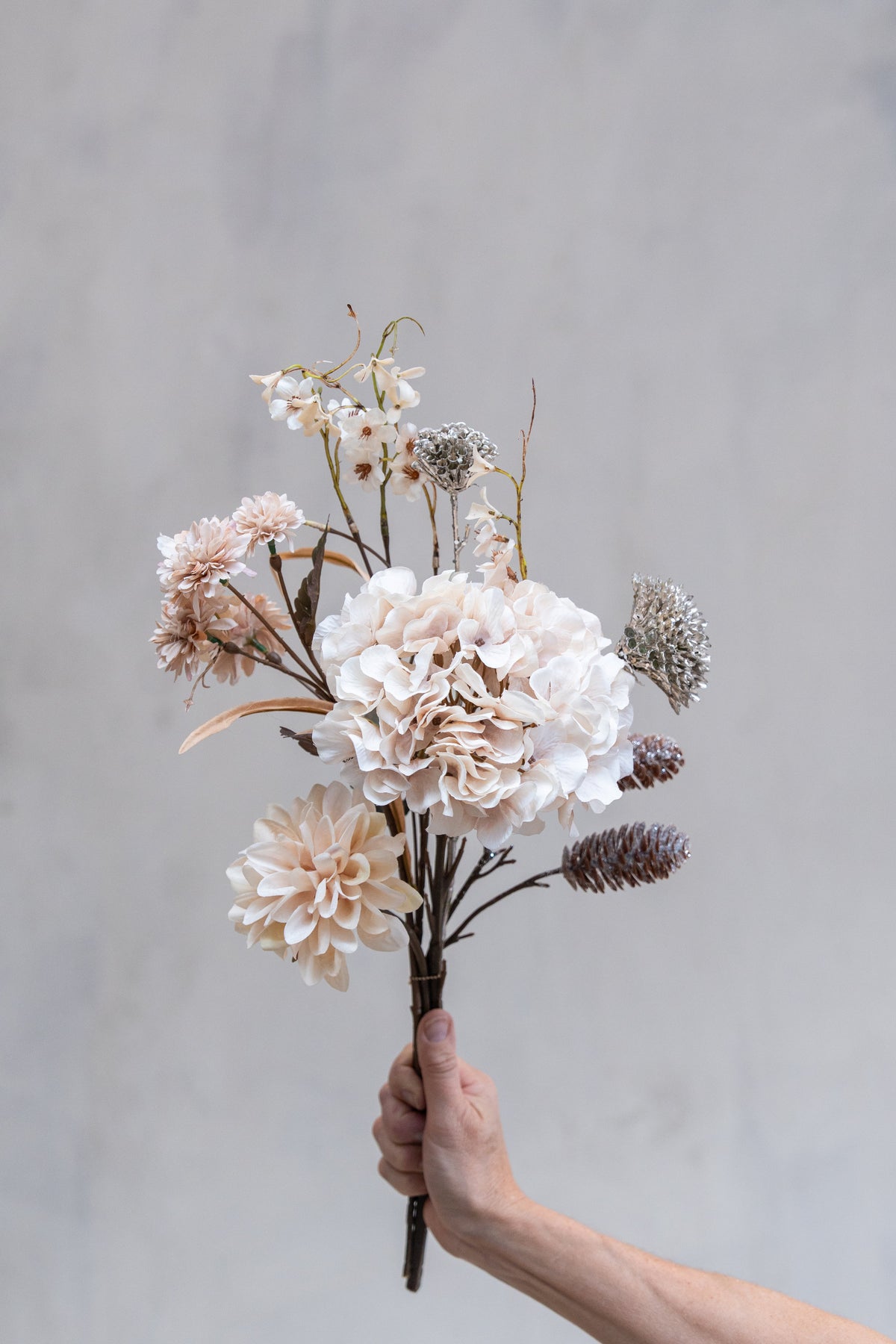 Bukett med kunstige rosa blomster og konglegrener med glitter fra Speedtsberg