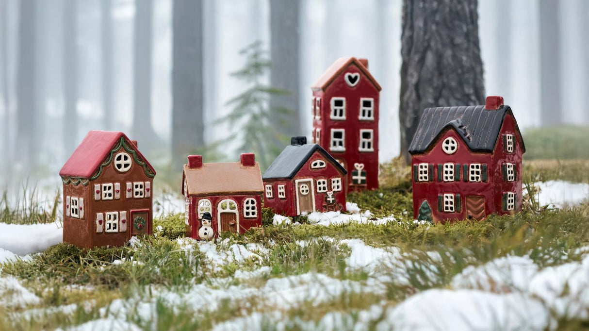 Stillenat Hus til fyrfadslys med kælk og julegaver fra Ib Laursen stående med andre huse som juleby