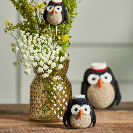 Studenterugler i ull ved en vase med blomster