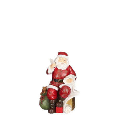Julemanden sidder med fjerpen, ønskeliste og gavesækken ved sin side fra House of seasons. 