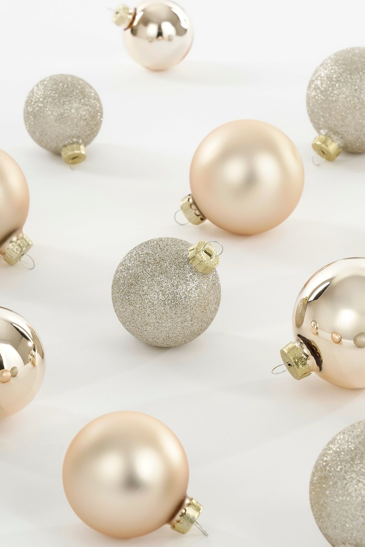 Julekuler i glass i kremfargede nyanser med matt, blank og glitteroverflate