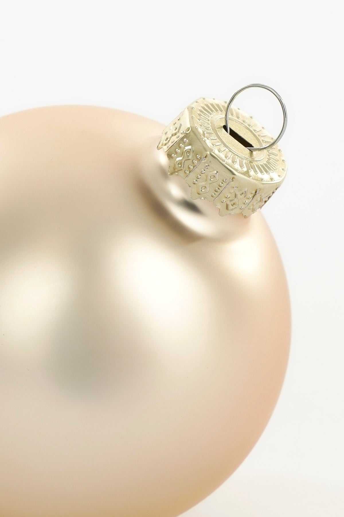 Toppen av matt kremfarget julekule i glass