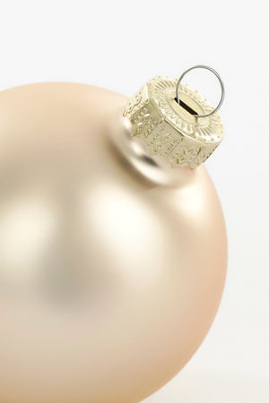 Toppen av matt kremfarget julekule i glass