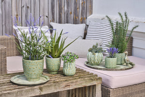 Antikkgrønt dekorasjonsfat fra Speedtsberg med blomster og grønne planter i en sommerlig oppstilling på et trebord