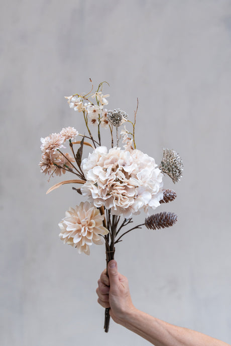Bukett med kunstige rosa blomster og konglegrener med glitter fra Speedtsberg