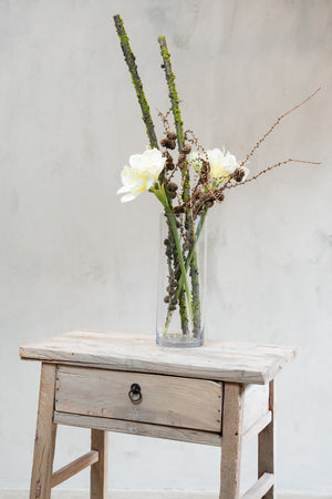 Vase med konglegrener, mosegrener og kunstige hvite amaryllisblomster fra Speedtsberg