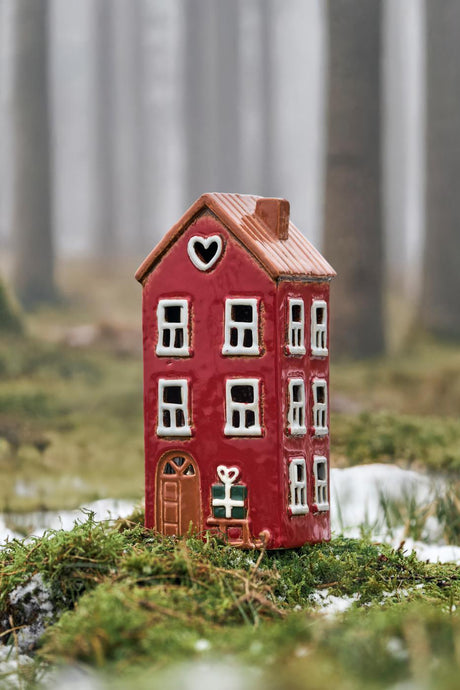 Stillenat Hus til fyrfadslys med kælk ved døren fra Ib Laursen stående på bund af mos