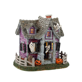 Ghost Cottage fra Lemax Spooky Town serien. Hus med spøgelser hængende ud af vinduerne hvidt gys. 