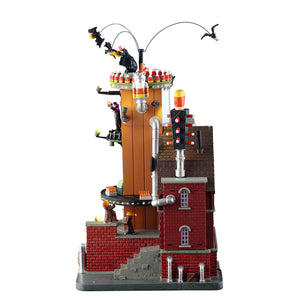 The Count's Candy Corn Factory med lys til Halloween by fra Spooky Town Lemax set fra siden med rør