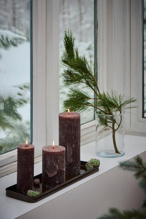 Aflang brun bakke fra Ib Laursen med bloklys og husløg på i vindueskarm