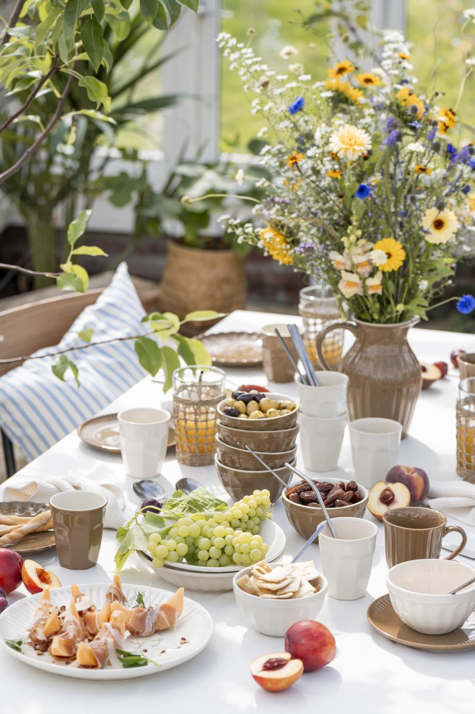 Mynte kande Hazelnut fra Ib Laursen på et udendørs sommerbord med blomster og servering